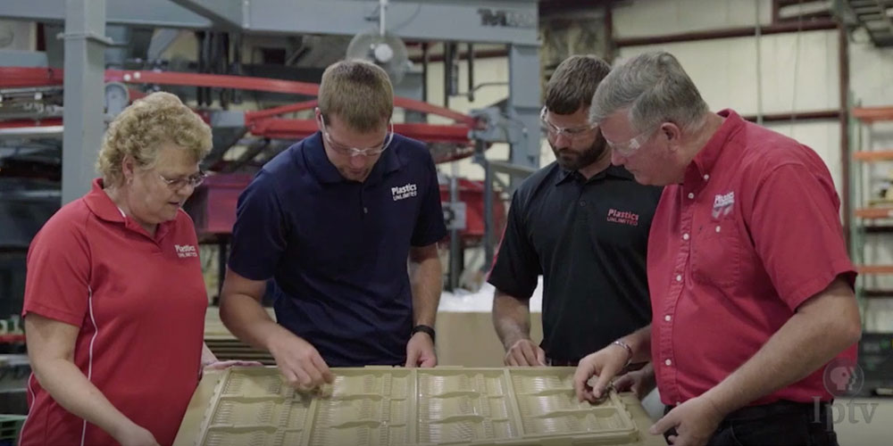 Reviewing a thermoformed tray that just came off the production line.