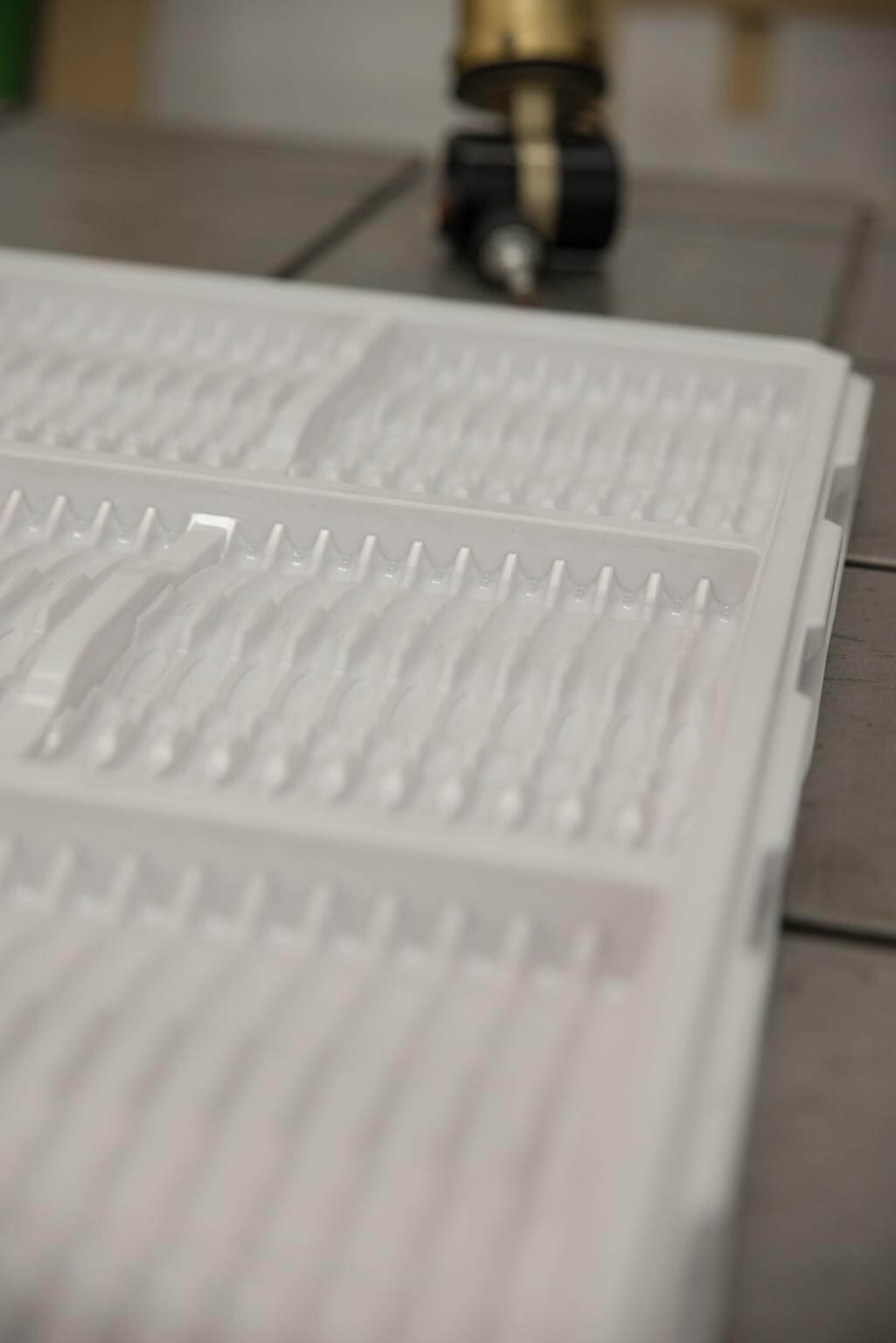 Pressure formed work in process tray used to transport toothbrushes.